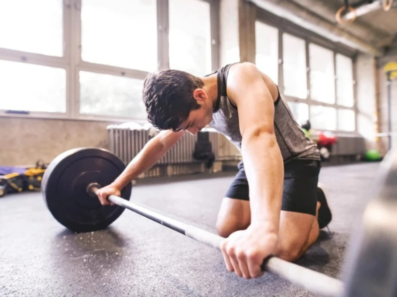 Người đang tập luyện thể thao và cơ bắp mệt mỏi do vận động quá mức